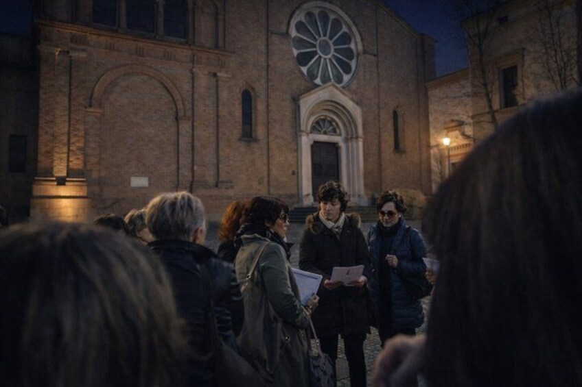 En grupp människor som står framför en kyrka med ett stort, runt fönster. 3