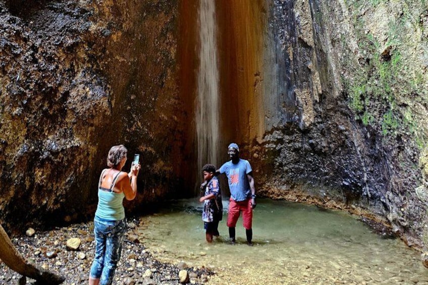 A waterfall, rocky terrain, and people observing the scene. 4
