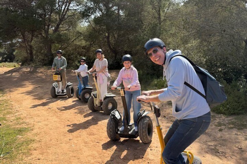 A group of people on Segway tracks in a wooded area. 4