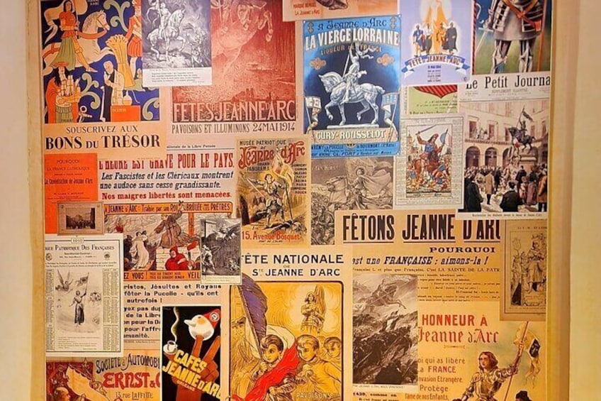 Un mur recouvert de divers affiches et publicités d’époque, notamment des titres tels que « Fêtes Jeanne d’Arc » et « La Vieille Dame ». 5