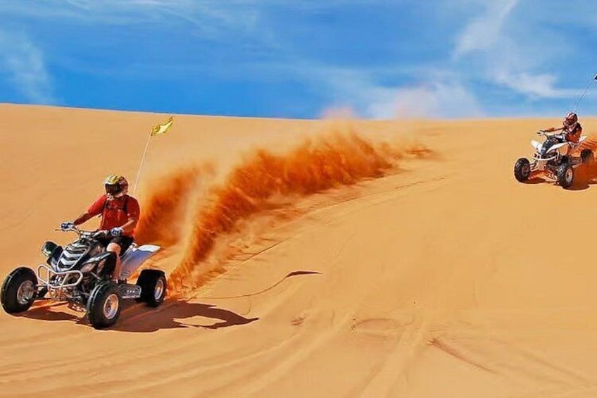 Two off-road vehicles on a sandy terrain with a clear sky. 1