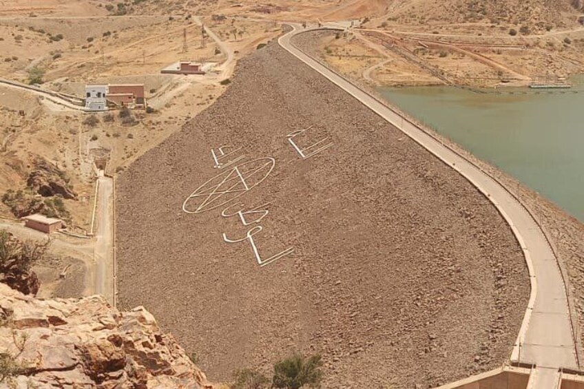A large reservoir with a dam, surrounded by arid terrain and sparse vegetation. 3