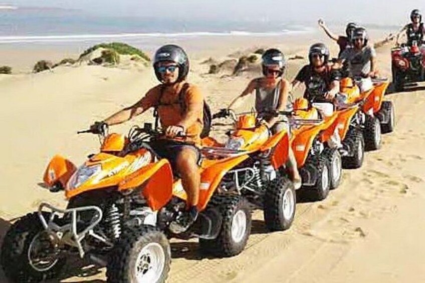 A group of people on ATVs on a sandy beach. 2