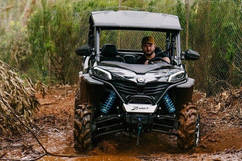 A black ATV with blue suspension on a muddy path. 3