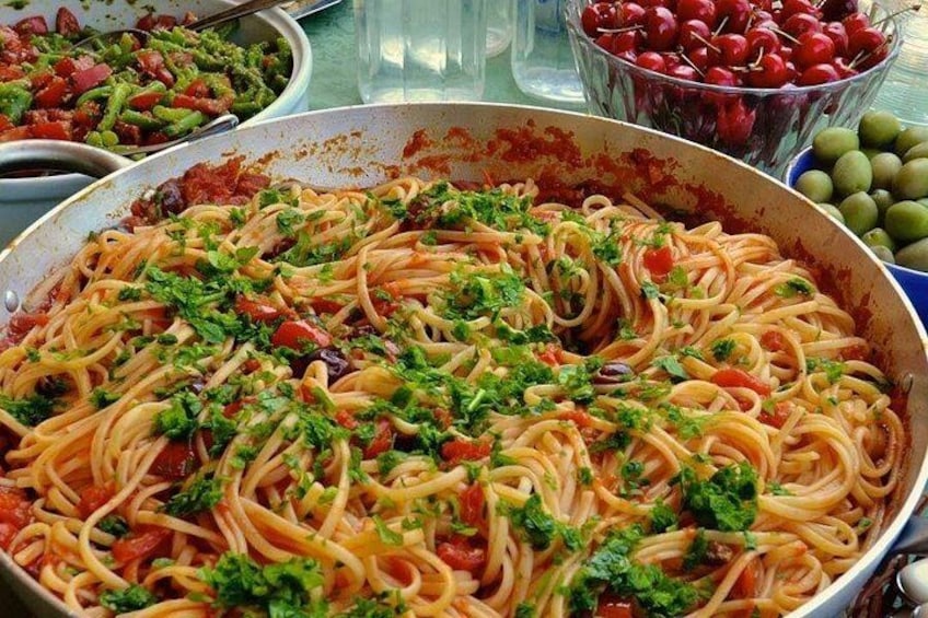 Una sartén grande de espagueti con tomates y hierbas. 2