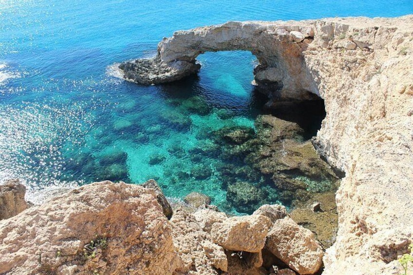 A natural rock formation with a clear blue sea. 5