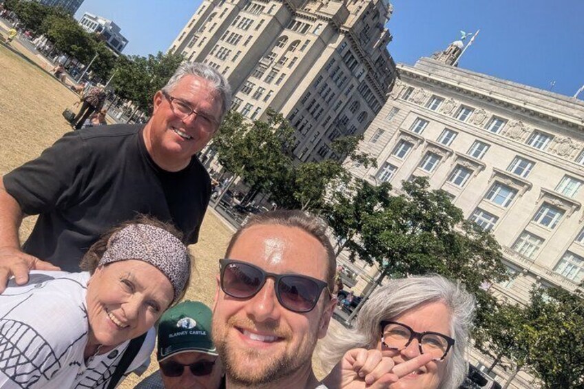 En gruppe mennesker tager en selfie foran en historisk bygning. 2