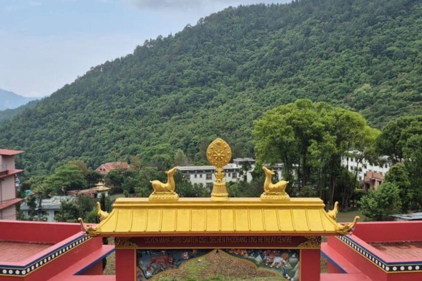 A temple with a golden roof and a mountain backdrop. 3