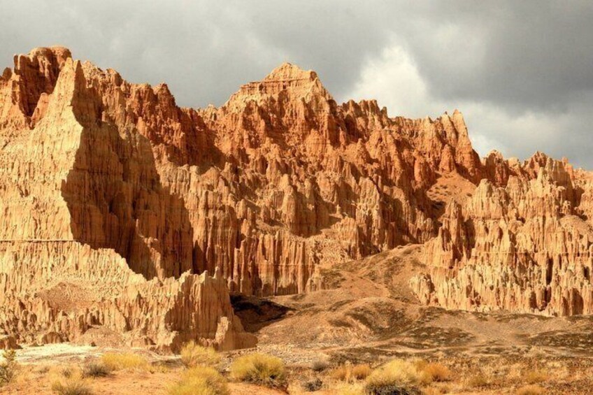 A rugged desert landscape with prominent rock formations and sparse vegetation. 3