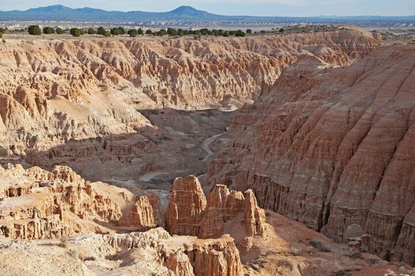 A rugged canyon landscape with layered rock formations and a winding river. 1