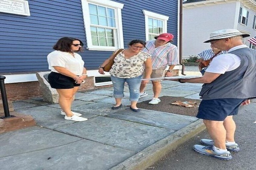 Una persona entregando una bandeja a un grupo de personas en una acera. 3
