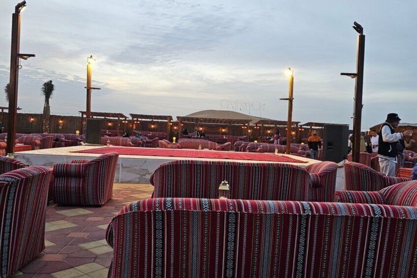 A terrace with striped seating and a view of a desert landscape. 5