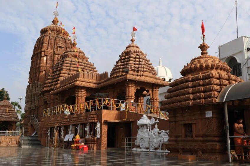 A temple with intricate architecture, a water body in front, and a statue of a deity. 3