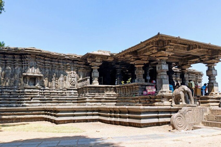 A stone temple with intricate carvings, a large open doorway, and a stone sculpture. 4