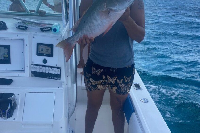 Une personne tenant un poisson sur un bateau. 2