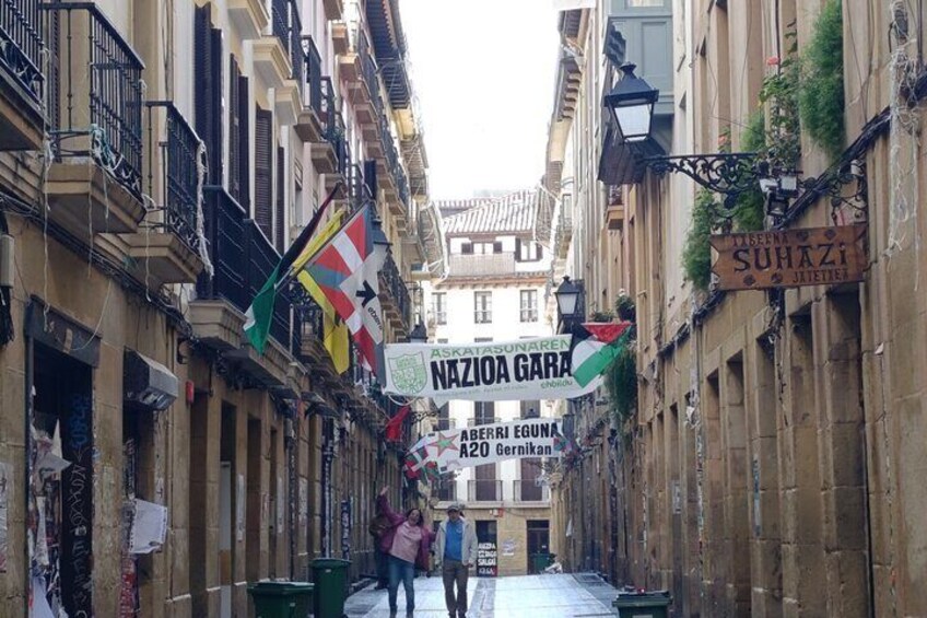 A narrow street with buildings, flags, and a banner reading 'NAZIONA GARA'. 5