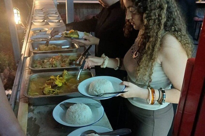 A buffet line with various dishes, including rice and vegetables. 1