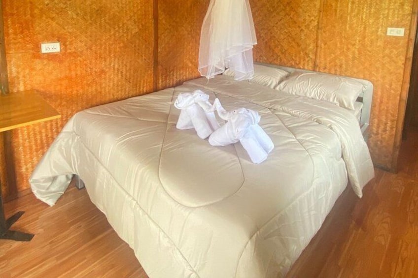 Un lit bien fait, avec du linge de lit blanc et une moustiquaire au-dessus. 5