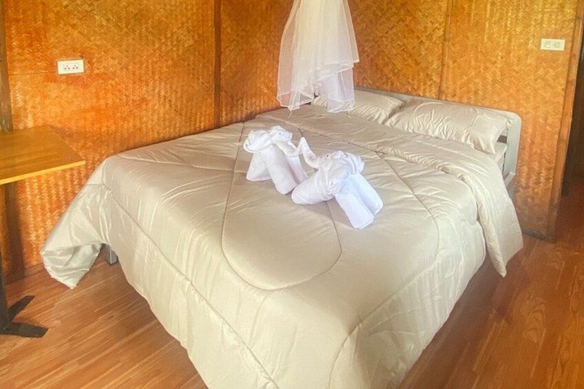 A neatly made bed with white linens and a mosquito net above it. 5
