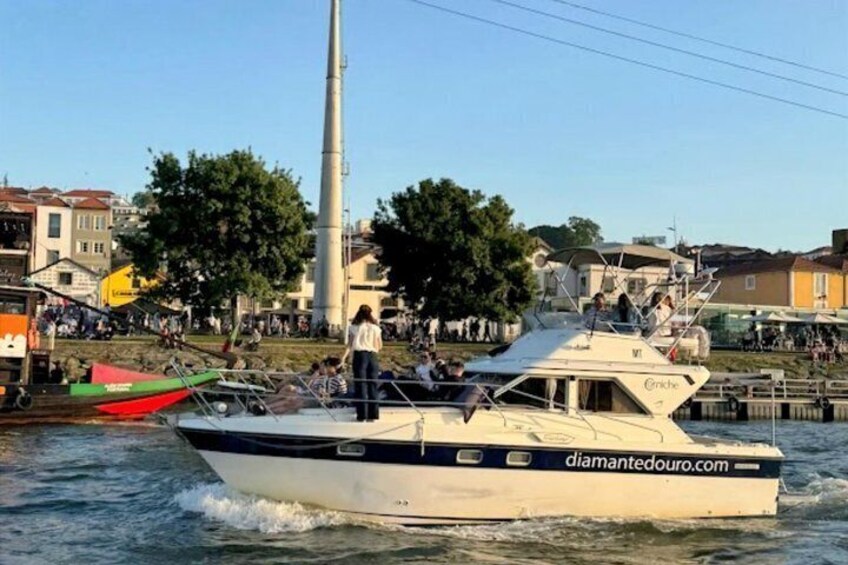 En båd med navnet 'Diamante Douro' på en flod, med en by silhuet i baggrunden. 5