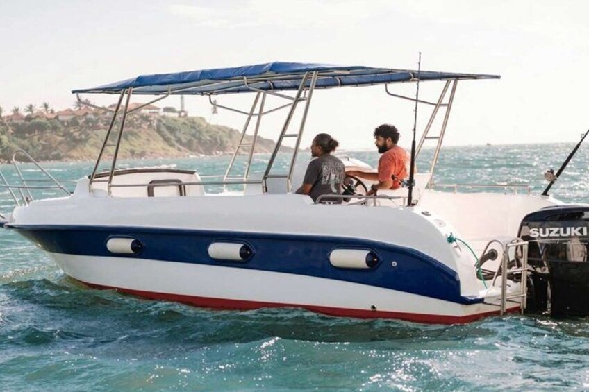 A boat with a blue and white color scheme, a Suzuki engine, and two people on board. 5