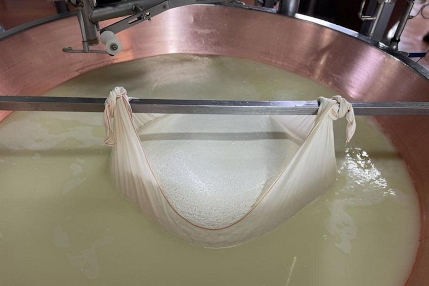 A large copper vat with a fabric hanging over a rod, submerged in a liquid. 2