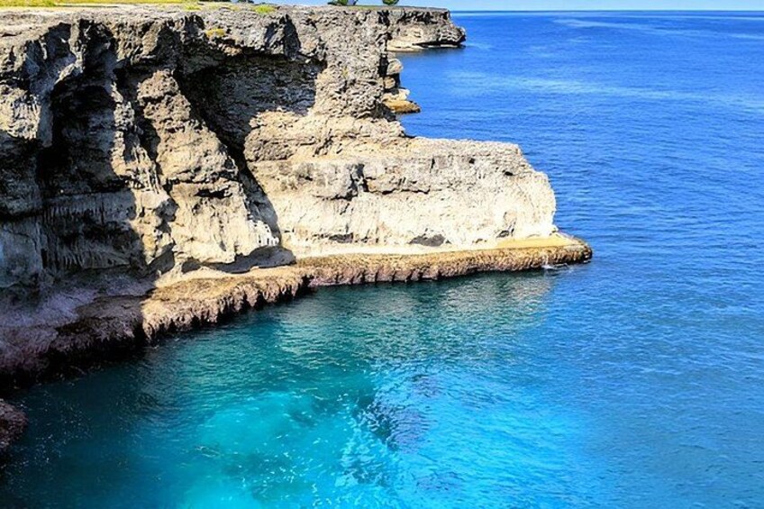 Una scogliera a picco sul mare con acqua cristallina e blu. 2