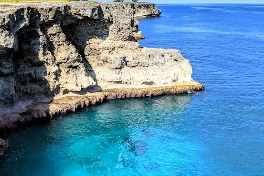 A coastal cliff with clear blue waters. 2