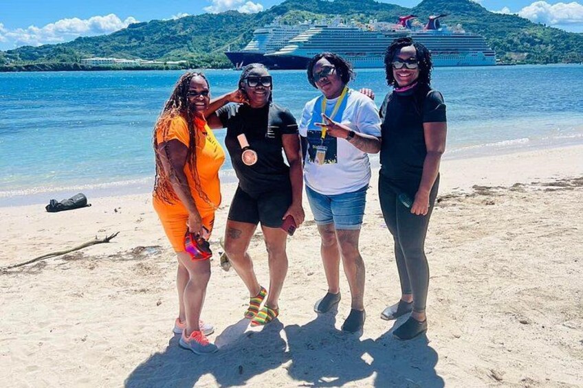 A group of people on a beach with a cruise ship in the background. 2
