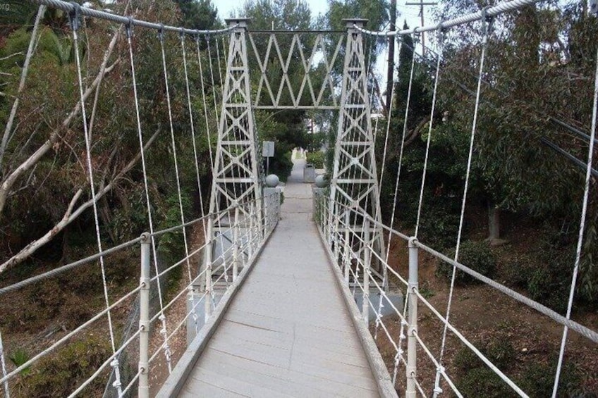 Un ponte sospeso con ringhiere in metallo e una passerella. 4