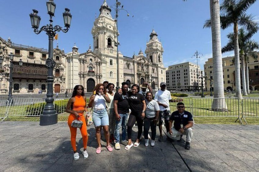 A group of people posing in front of a historic building with ornate architecture. 5
