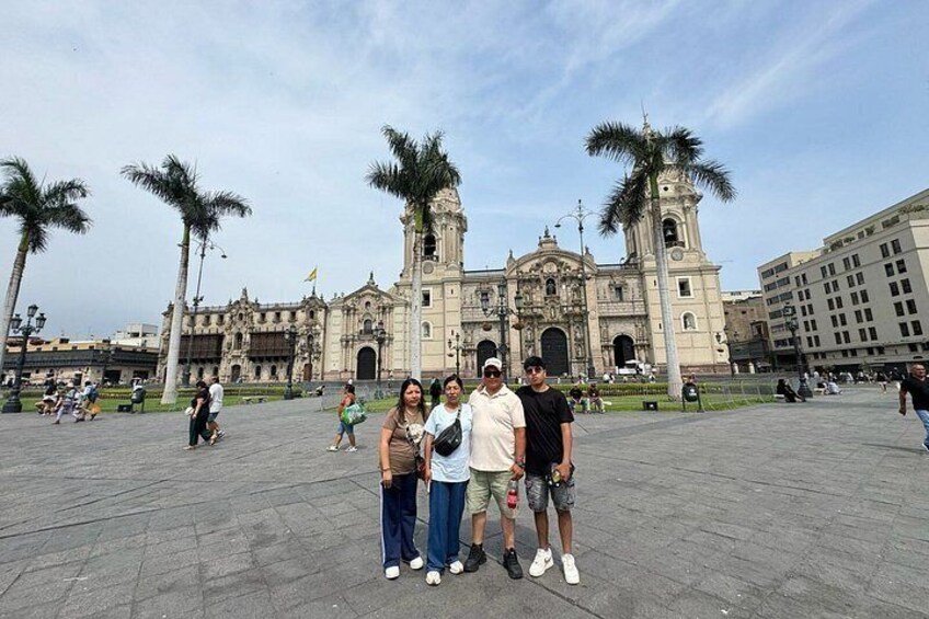 Un grupo de personas frente a un edificio histórico con dos torres destacadas. 5