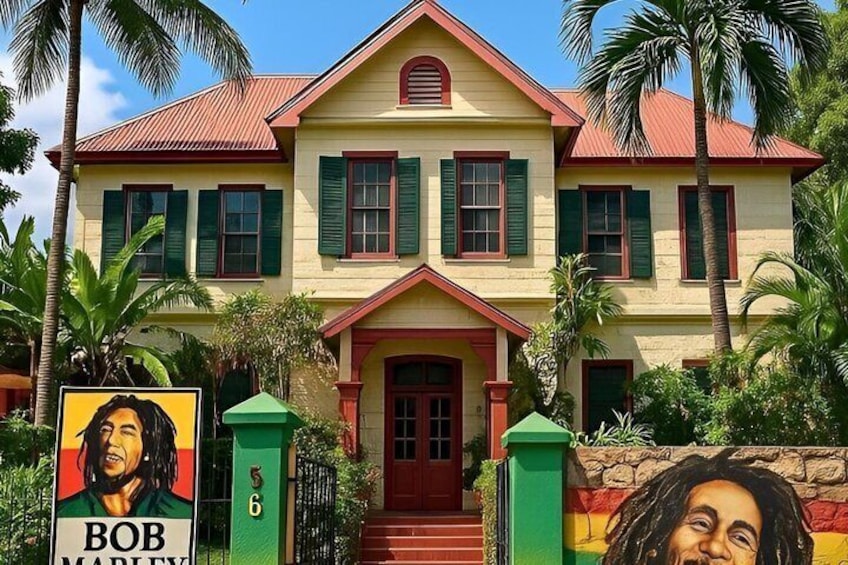 A two-story house with a red roof, green shutters, and a front porch. 2