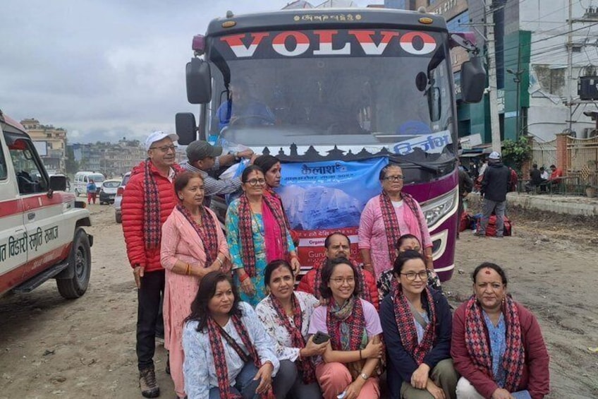 A group of people posing in front of a Volvo bus with a banner. 3