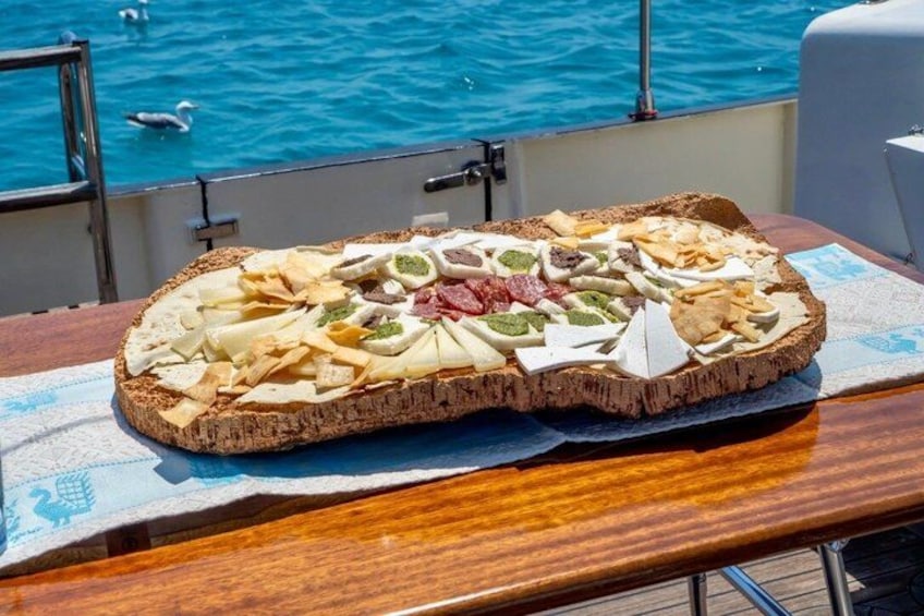A pizza on a wooden table with a view of the sea and swans in the background. 3