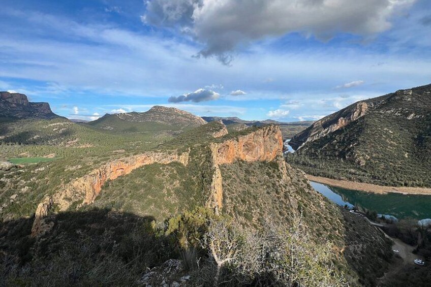 A canyon with a river, mountains, and a clear sky. 2