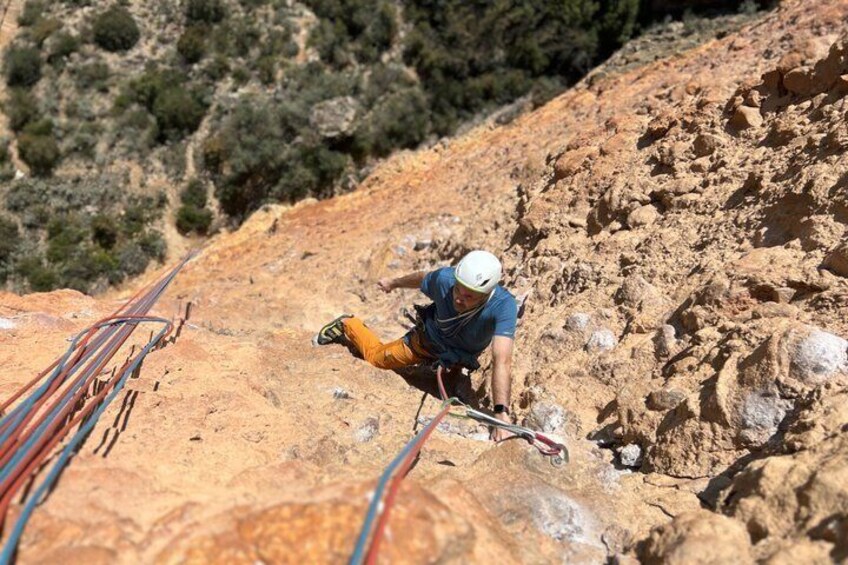 A person rappelling down a rocky slope with safety ropes. 2