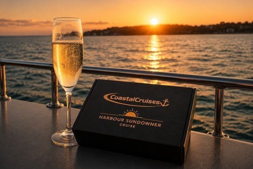 Une coupe de champagne sur une table, à côté d’une enseigne indiquant « CoastalCruises ». 2