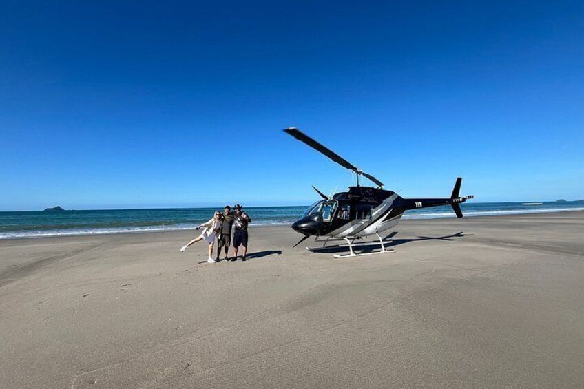 Un helicóptero en una playa con cielo despejado. 4