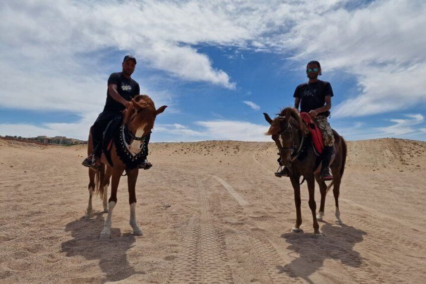 Deux personnes à cheval, sur un sentier sablonneux, sous un ciel dégagé. 3