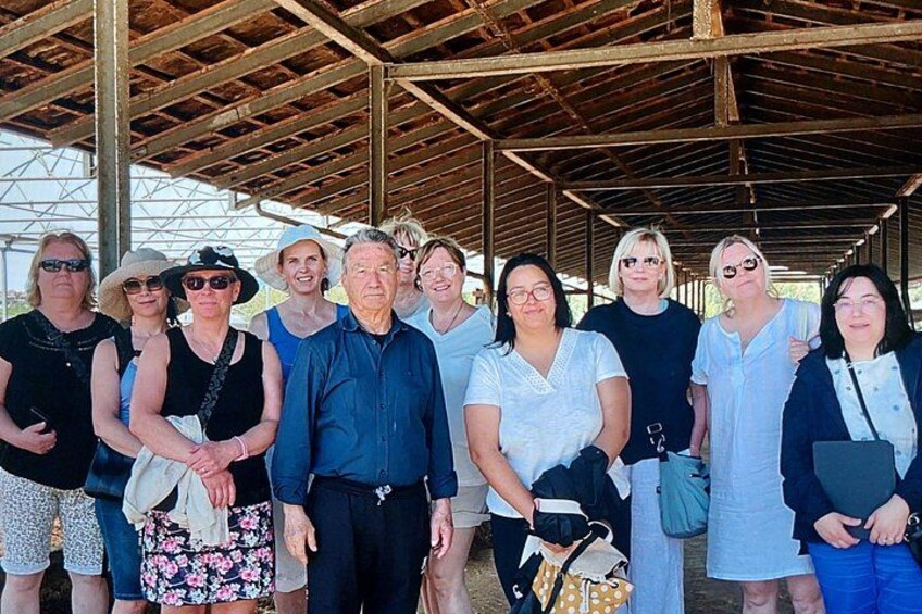 Un groupe de personnes se tient sous une structure abritée, recouverte d’un toit en métal. 4
