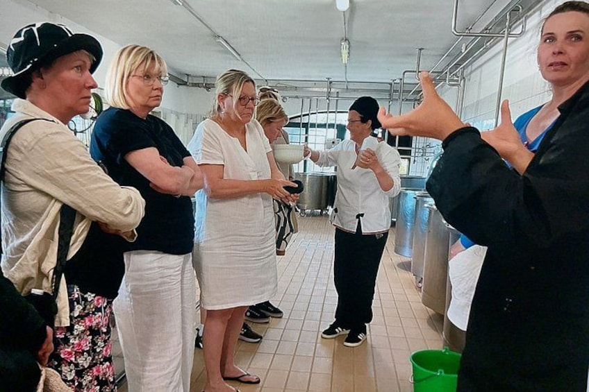Un groupe de personnes se trouve dans une cuisine, certaines tenant des bols, dans un environnement de cuisine professionnelle. 5