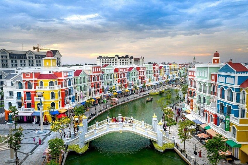 A colorful waterfront promenade with a bridge, buildings, and a canal. 1