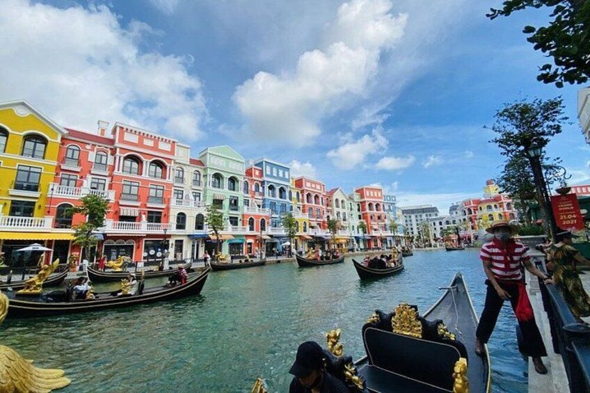 A canal with colorful buildings on one side and gondolas on the water. 2