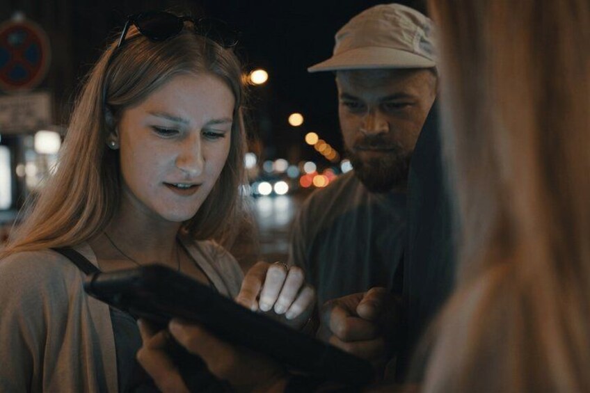 Due persone, una con uno smartphone in mano, in strada di sera. 2