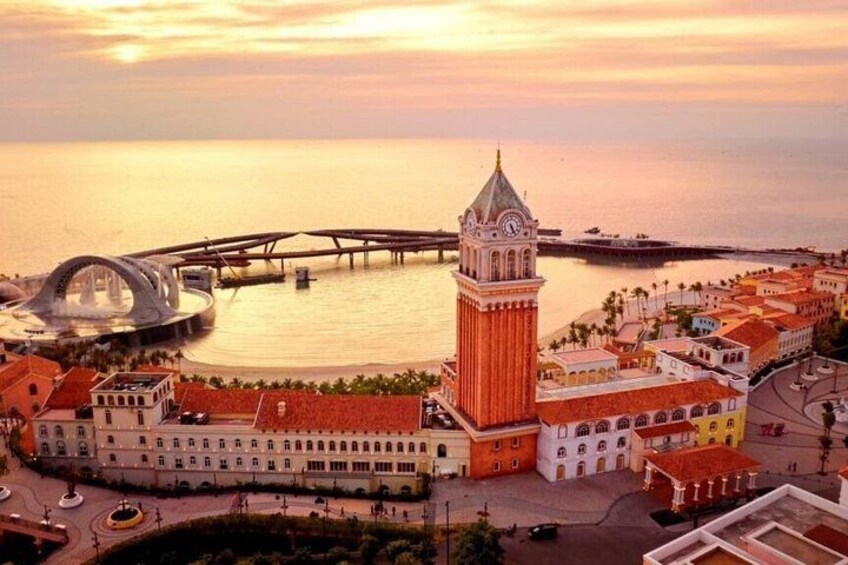 A coastal cityscape with a prominent clock tower, a modern bridge, and historic buildings. 5