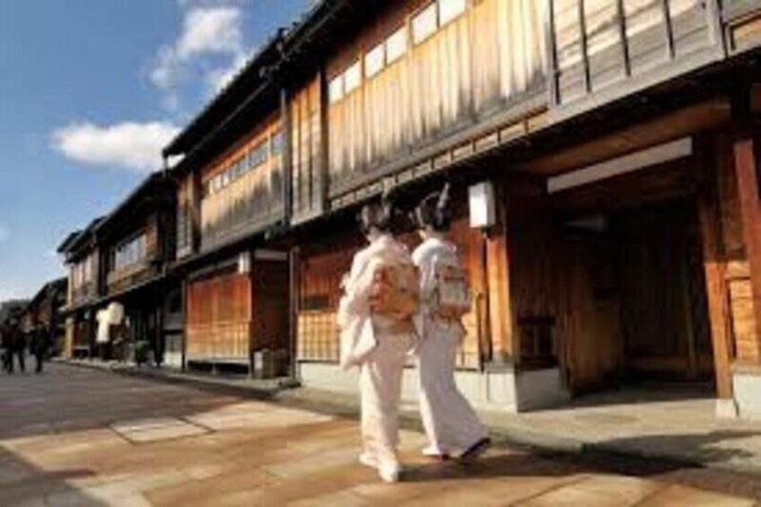 A traditional Japanese street with wooden buildings and pedestrians. 2