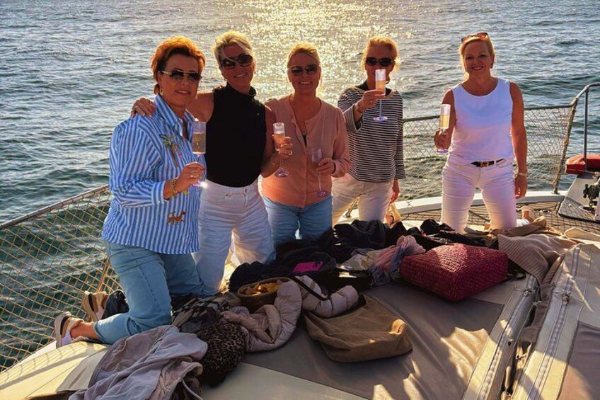 A group of people on a boat with luggage and personal items scattered on the deck. 2