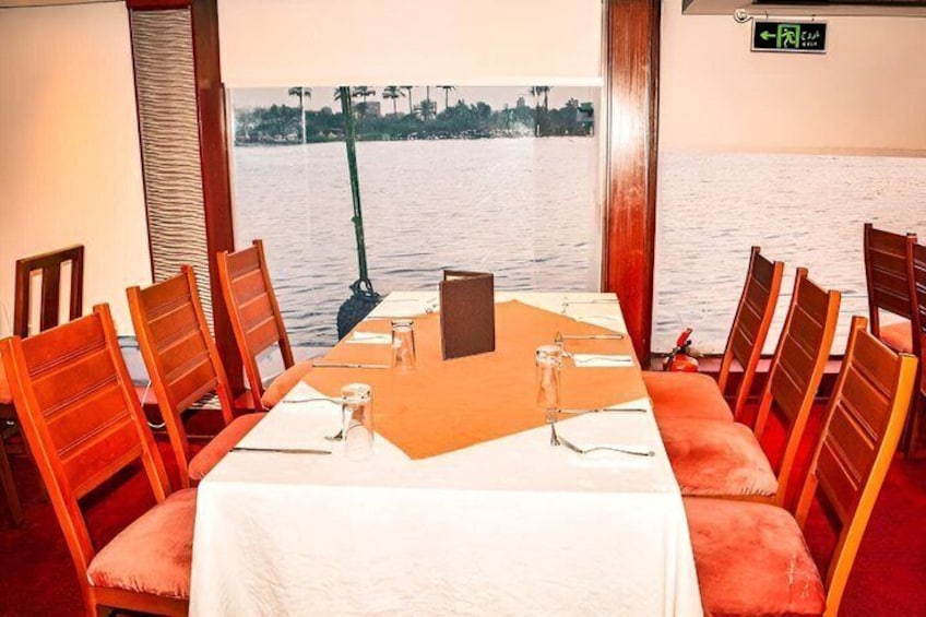 A conference room with a table set for eight, overlooking a body of water. 4