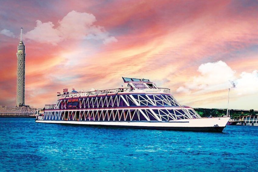 A large, multi-deck cruise ship with a distinctive geometric pattern on its side, docked near a tall tower and a sunset sky. 5